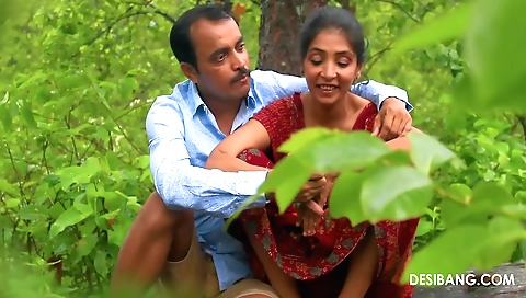 Indian brunette in white shirt and red dress in the jungle